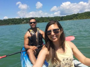 A man and woman kayak together across a lake in Branson, Missouri